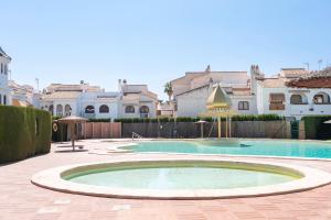 una grande piscina in un cortile con case di Casa en la playa con piscinas costa a Santa Pola