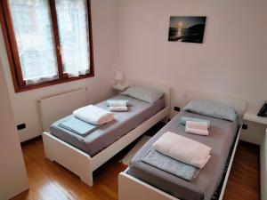 twee bedden in een kamer met twee ramen bij Appartamento AZZURRO in Cannobio +88 foto's