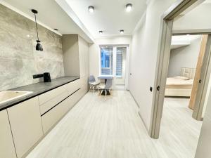 a kitchen with a sink and a table and a bed at Замечательная новая квартира на Ботанике in Chişinău +44 photos