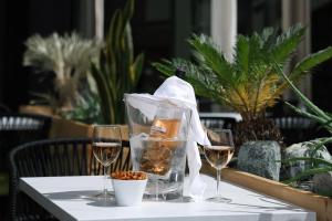 a table with two glasses of wine and a basket of nuts at Le Néliö in Aix-en-Provence
