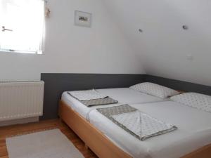 a bedroom with a bed with white sheets and a window at Cottage Stela Bohinj in Bohinj