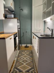 a kitchen with a sink and a counter with a rug at Your Chic Vibrant APT in Helsinki