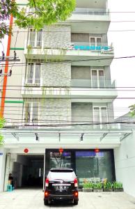 a car parked in front of a building at Frank's Hotel in Surabaya