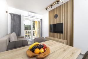 a room with a table with a bowl of fruit on it at Villa Vista Jelsa in Jelsa