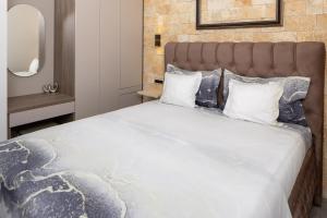 a bedroom with a large bed with white sheets and pillows at Villa Vista Jelsa in Jelsa
