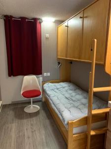 une chambre avec un lit superposé et une chaise dans l'établissement Campanules, à Courchevel