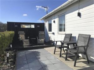 twee stoelen en een tafel op een terras naast een huis bij 3 Bedroom Detached Holiday Chalet SouthShore Park in Bridlington
