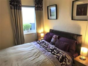 een slaapkamer met een bed met twee lampen en een raam bij 3 Bedroom Detached Holiday Chalet SouthShore Park in Bridlington
