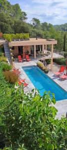 a swimming pool with chairs and a house at Les Hauts du Peireguier in La Motte