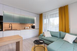 a living room with a blue couch and a kitchen at Sunset Resort 109 in Fonyód
