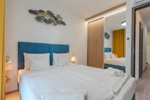 a bedroom with a large white bed with a blue headboard at Sunset Resort 109 in Fonyód