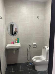a bathroom with a toilet and a sink and a mirror at Homestay Idamanku in Shah Alam
