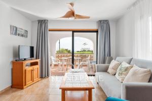 a living room with a couch and a table at South Facing Garden Holiday in Heated Pool Complex FC715 - 2xSt in San Miguel de Abona