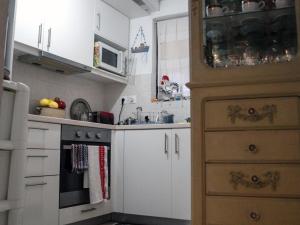 une petite cuisine avec des armoires blanches et un micro-ondes dans l'établissement Sylvia's House - a unique waterfront location, à Kokkari 27 autres photos