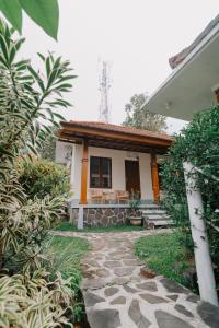 a house with a stone walkway in front of it at Armaya Guest House in Gitgit