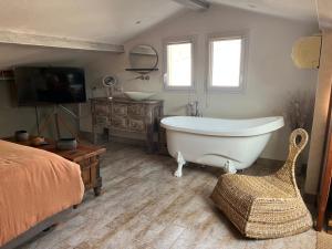a bathroom with a tub and a bed and a television at Charmante maison - Résidence Les Logis du Boucharel, Confort et Détente in Les Issambres