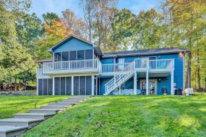 a blue house with stairs leading up to it at Waterfront Lake House Ideal Dock for Boats, Swimming, Fishing in Moneta