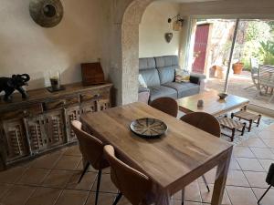 a living room with a wooden table and chairs at Charmante maison - Résidence Les Logis du Boucharel, Confort et Détente in Les Issambres