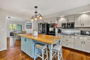 a large kitchen with a blue island with bar stools at Waterfront Lake House Ideal Dock for Boats, Swimming, Fishing in Moneta