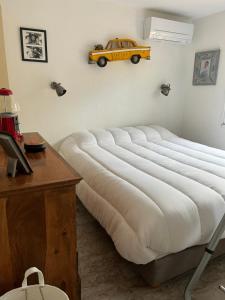 a large white bed with a yellow car on the wall at Charmante maison - Résidence Les Logis du Boucharel, Confort et Détente in Les Issambres +14 photos