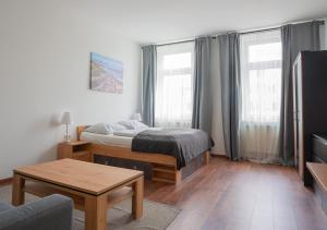 a bedroom with a bed and a coffee table at New Favoriten - Serviced Apartments in Vienna