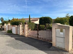 a fence with a gate in front of a house at Charmante maison - Résidence Les Logis du Boucharel, Confort et Détente in Les Issambres