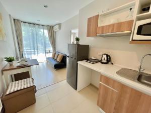 una cocina con fregadero y refrigerador en 1 bedroom pool view in Bangtao, en Thalang
