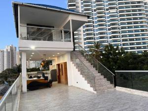una casa con una escalera frente a un edificio alto en CASA frente al mar, en Gaira