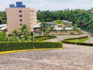 a park with bushes and a building in the background at Gran Lençóis Flat Residence in Barreirinhas