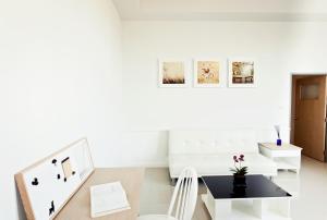 a white living room with a black table and white chairs at The Eight in Samut Sakhon
