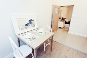 a dining room table with white chairs and a painting at The Eight in Samut Sakhon