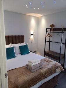 ein Schlafzimmer mit einem Bett mit Handtüchern darauf in der Unterkunft Casa De Niveles Near Beach Local Comfort in Weymouth