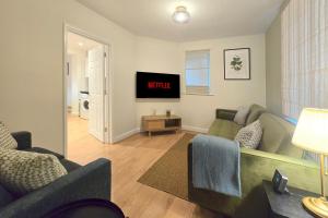 Una sala de estar con dos sofás y un televisor. en Charming 5-Bed Home with Garden and Parking, en Winchester