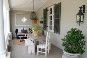 a dining room with a table and chairs and a couch at Madeliefie Guest Accommodation in Paarl