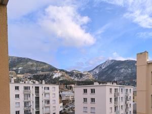 two white buildings with mountains in the background at T2 cosy proche des pistes in Briançon