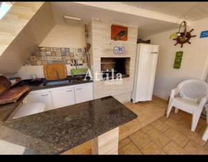 a kitchen with a counter top and a refrigerator at Suíte na Cobertura Enseada in Guarujá