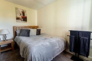 Un dormitorio con una cama y una mesa con una lámpara. en 12FWC, 2 Bedroom Apartment, Sleeps 4, Free Parking, Town Centre Location, en Swindon