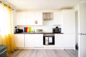 a kitchen with white cabinets and a microwave at 18CB 2 bedroom Apartment, Sleeps 4, Long Stays, Free Parking in a great location in Swindon