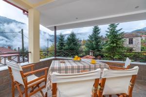 a dining room with a table and chairs on a balcony at Villa Kleino - 30 min from Meteora in Kalabaka