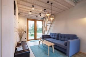 a living room with a blue couch and a table at Modern Svencelė Cottage I-Friends and Family in Svenele