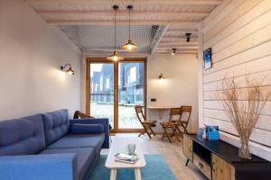 a living room with a blue couch and a table at Modern Svencelė Cottage I-Friends and Family in Svenele
