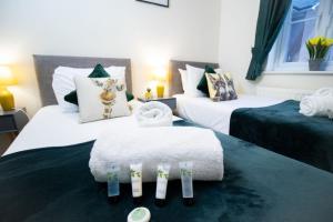 a hotel room with two beds with towels on them at Brunel Apartment, Sleeps 4, 2 Bedrooms, Free parking, Long stay disc in Swindon +8 photos