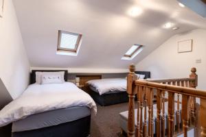 una camera mansardata con 2 letti e una scala di Edinburgh Street, Sleeps 9, 4 Bedrooms, Wifi, Long Stay Disc a Upper Stratton