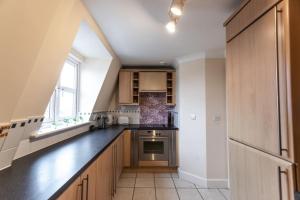 kuchnia z drewnianymi szafkami i czarnym blatem w obiekcie 12 Bradford Old Town Swindon, 2 Bedroom, Sleeps 5, Free Secure Parking, Wifi, Long Stay Disc w mieście Swindon