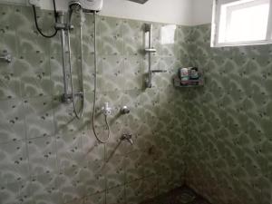 e bagno con doccia e parete piastrellata. di Nobel Regency a Bibile