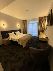 a hotel room with a bed and a chair at Black Tulip Hotel in Dej +74 photos