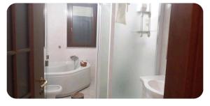 a bathroom with a tub and a toilet and a sink at Casa del Viandante in Nichelino