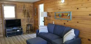 un soggiorno con un divano blu e una televisione di Castaways Cottage on Croton Pond #2 a Newaygo