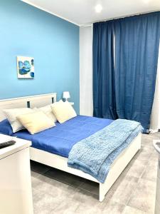 una camera da letto blu con un letto con una parete blu di Siculahome23 a Catania