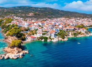 The Lemoni House -Skyathos- 1-bedroom apartment في مدينة سكياثوس: اطلالة جوية على مدينة على شاطئ الماء